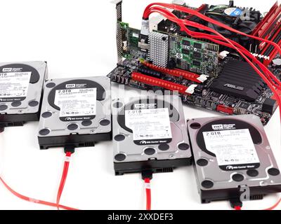 Closeup of four hard drives connected to computer motherboard with a RAID controller Stock Photo