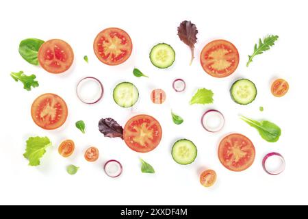Fresh vegetable salad ingredients, shot from the top on a white background. A flat lay composition with tomato, cucumber, onion slices and mezclun lea Stock Photo
