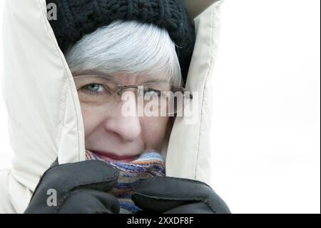 Woman, 50+, with cap and hood in winter Stock Photo