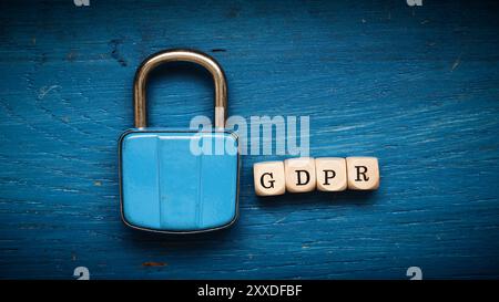 Old used padlock on a blue rustic wooden background, GDPR concept image Stock Photo