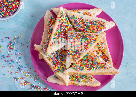 Slices of fairy bread on a pink plate. Fairy bread is a traditional Australian party food Stock Photo