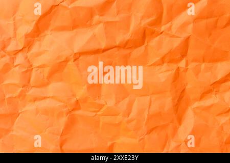 Top view and full frame of wrinkled or crumpled orange paper is used as crumpled orange paper background texture. Stock Photo