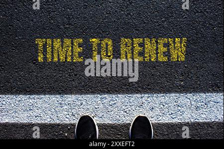 Time to renew message written on asphalt road. Conceptual time to renew symbol. Copy space. Stock Photo