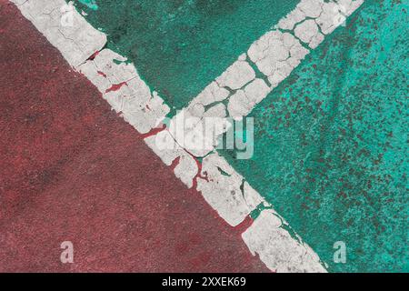 white line painted on red and green textured road surface Stock Photo
