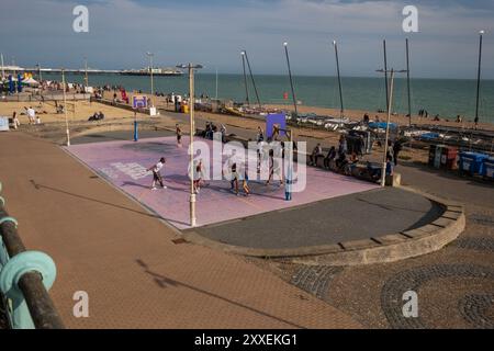 A community basketball court with players on at Brighton beach seafront England playing on a sunny evening. Stock Photo