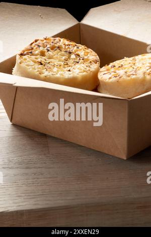 Crumpets in a cardboard tray, fresh from a bakery. Biodegradable plastic free eco friendly packaging. Stock Photo