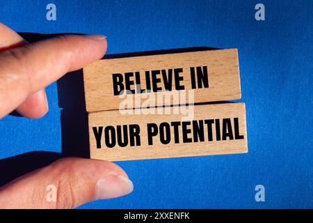 Believe in your potential message written on wooden blocks on blue background. Conceptual believe in your potential symbol. Copy space. Stock Photo