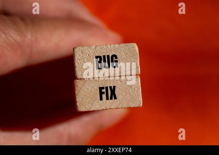 Bug fix message written on wooden blocks with orange background. Conceptual bug fix symbol. Copy space. Stock Photo