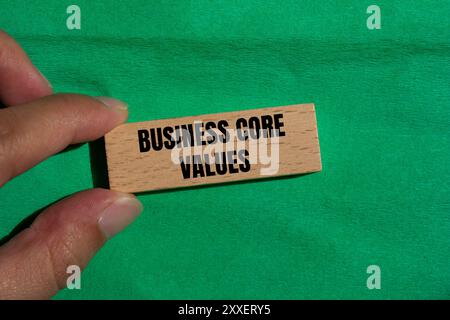 Business core values message written on wooden block with green background. Conceptual business core values symbol. Copy space. Stock Photo