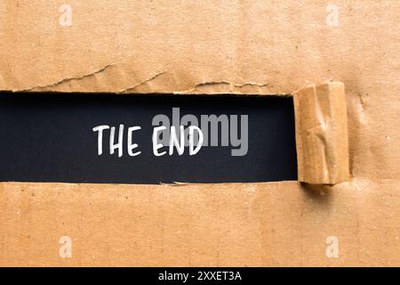 The end message written on ripped torn cardboard paper with orange ...