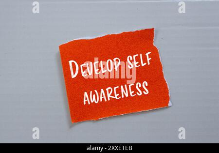Develop self awareness message written on ripped torn orange paper ...
