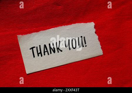 Thank you message written on ripped torn paper piece with stone ...