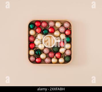 Creative Christmas layout made with colorful Xmas baubles and cup of coffee on pastel cream background. Minimal Christmas and New Year concept. Stock Photo