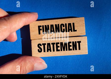 Financial statement message written on wooden blocks with blue background. Conceptual financial statement symbol. Copy space. Stock Photo