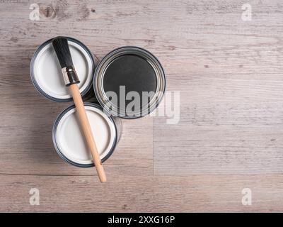 Cans of paint with paintbrush on a wooden background with copy space. Stock Photo
