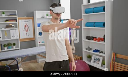 A young hispanic man wearing a vr headset in a modern physical therapy clinic Stock Photo