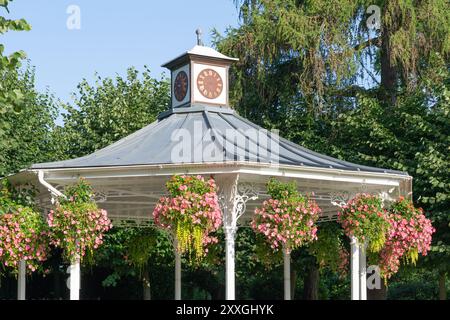 The bandstand is a historic monument in the War Memorial Park in Basingstoke. Seen here newly painted with hanging flower baskets in late summer. UK Stock Photo