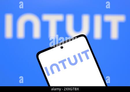 In this photo illustration, the Intuit Inc. logo is displayed on a smartphone and in the background. Stock Photo