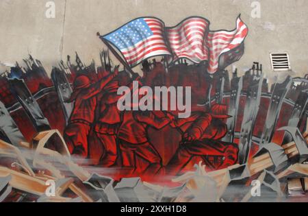 Queens, New York, USA, February 15th 2002:: A mural not far from the MoMAQueens is depicting firemen rising an american flag from the ruins of World Trade Center. Stock Photo