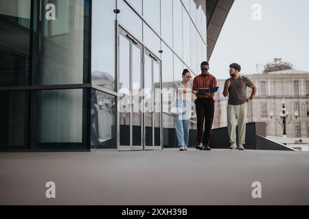 Business people collaborating outdoors in an urban city setting near modern building Stock Photo