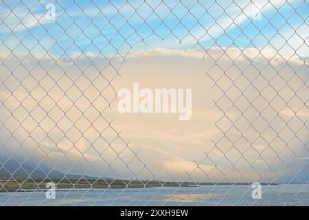 Hole in a wire mesh fence Stock Photo