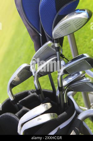 Golf clubs in golfbag, green grass background Stock Photo