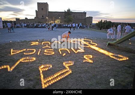 Castilian boy lighting candles, Pedraza Castle in the background, Conciertos de las Velas festival of lights, Pedraza, Segovia province, Castile and L Stock Photo