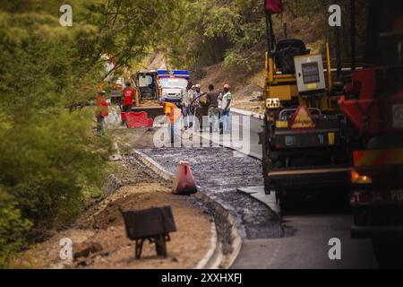 A group of workers apply a new layer of asphalt to the road Stock Photo