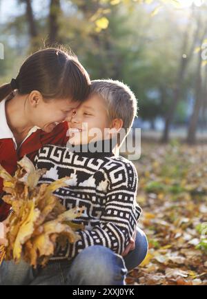 Mother and her son walking in a autumn park Stock Photo