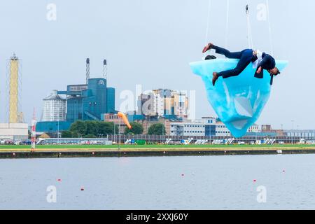 London, UK, 24th August, 2024. The European premiere of 'THAW' at the Greenwich+Docklands International Festival (GDIF) featured three aerial performers atop a melting 2.5-tonne block of ice, suspended over Gallions Point Marina, over the course of 8 hours. The perfomance, repeated again on the 25th August, viewable from the University of East London in Newham, was created by Australian theatre company, Legs On The Wall, after the bushfires of 2019/20 and urges humanity to tackle the climate crisis. Credit: Eleventh Hour Photography/Alamy Live News Stock Photo