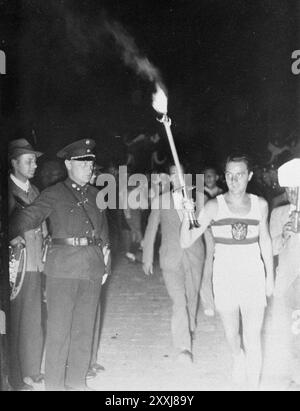 The Olympic torch ariving at the Berlin stadium for the 1936 Oylmpics Stock Photo