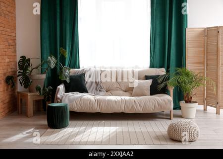 Comfortable sofa near window with green curtains in living room Stock Photo