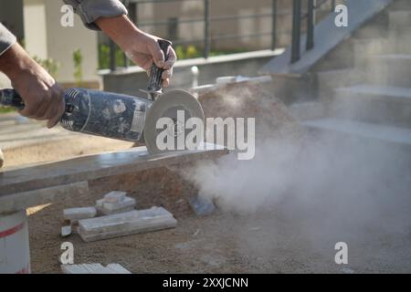 Concrete cutting is currently being conducted with a power tool on a busy construction site Stock Photo