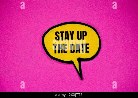 Stay up the date message written on yellow paper speech bubble with pink background. Conceptual stay up the date symbol. Copy space. Stock Photo