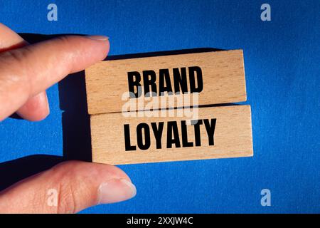 Brand loyalty message written on wooden blocks on blue background. Conceptual brand loyalty symbol. Copy space. Stock Photo