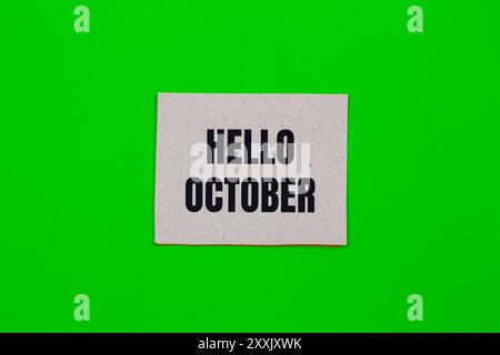 Hello october message written on paper piece with green background. Conceptual hello october symbol. Copy space. Stock Photo