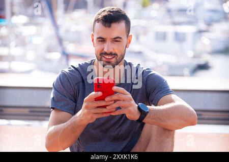 Young athlete using apps on the phone to keep track of their exercise routine. Stock Photo
