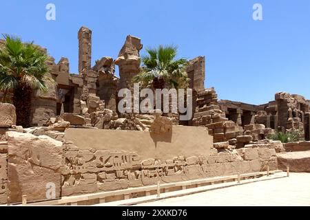 Visitors marvel at the intricate hieroglyphs and impressive bas reliefs on the ancient walls of the Karnak temple complex in Egypt, reflecting its his Stock Photo