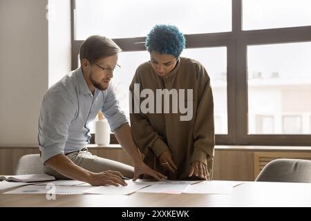 Two multiethnic colleagues working together in office Stock Photo