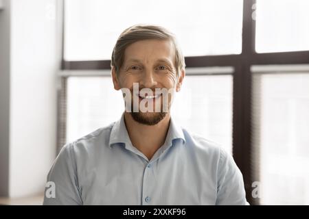 Businessman casually dressed in shirt, smiling confidently posing for camera Stock Photo