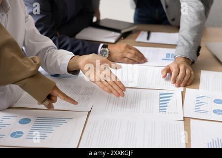 Businesspeople planning strategy based on data, engaged in teamwork, closeup Stock Photo