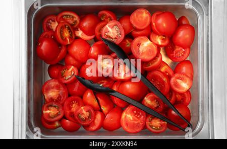 Sliced tomatoes in a metal container. Stock Photo