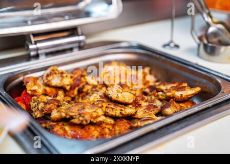 Lots of fried chicken thighs in a metal tray. Stock Photo