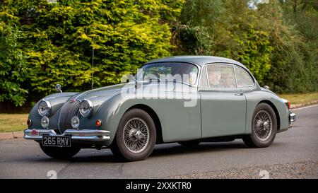 Whittlebury,Northants.,UK - Aug 25th 2024: 1958 grey Jaguar XK classic car driving on a British country road. Stock Photo