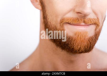 Beard is his style. Close-up of bearded man smiling while standing against white background Stock Photo