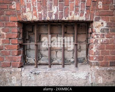 basement window blocked with bricks and covered with bars in old building in Kaliningrad city, Russia Stock Photo