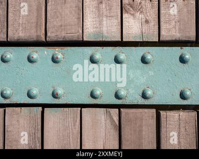 wooden deck boards and green painted iron plate on flooring of pier in port in Kaliningrad city on sunny summer day Stock Photo