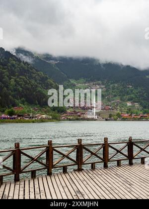 Uzungol, Turkey - May 4, 2024: view of Uzungol village from pier on Usungol lake in green overgrown mountains in Caykara district of Trabzon province, Stock Photo