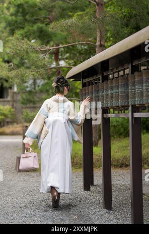 Unidentified Japanese woman in wearing traditional Hakama standing in a shrine. Stock Photo