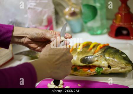 Delicious fresh fish carp in the hands of the cook, ingredients for healthy food, diet or cooking concept, selective focus. Stock Photo